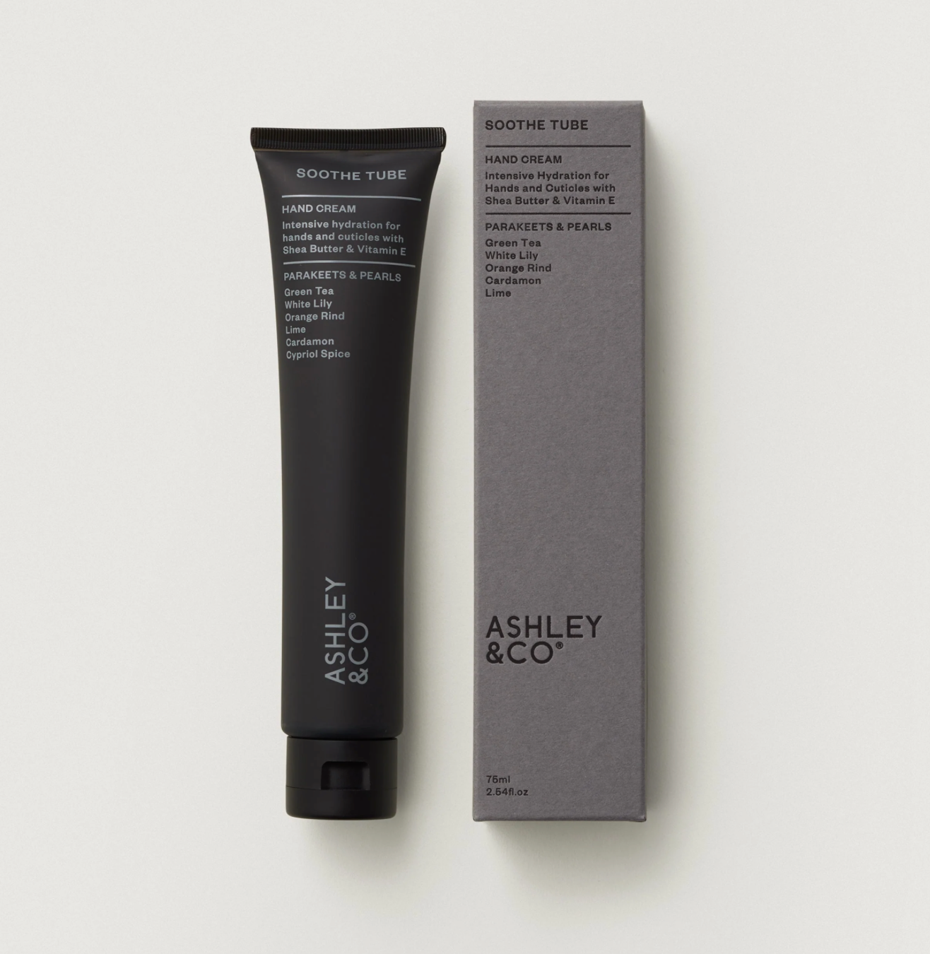 Two boxes of Ashley & Co soothe tube and Fruney dark chocolate products on a wooden surface with tulips in the background.
