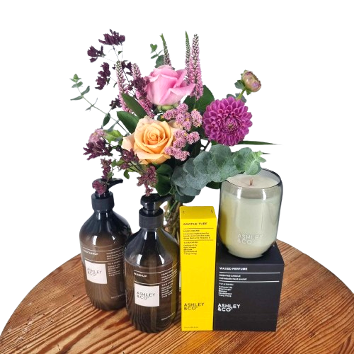 A collection of Ashley & Co pamper products and a scented candle