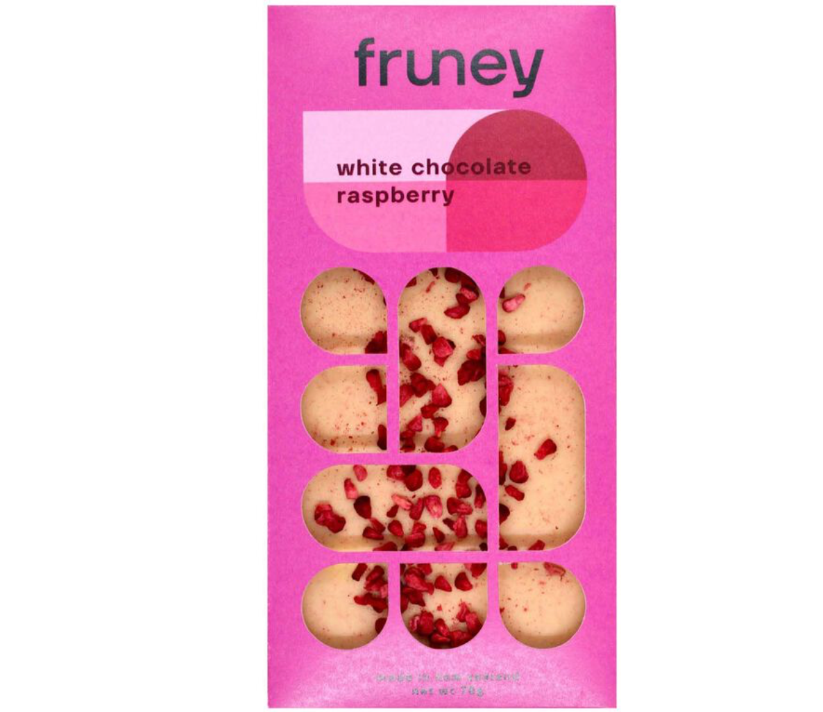 Two boxes of Ashley & Co soothe tube and Fruney dark chocolate products on a wooden surface with tulips in the background.