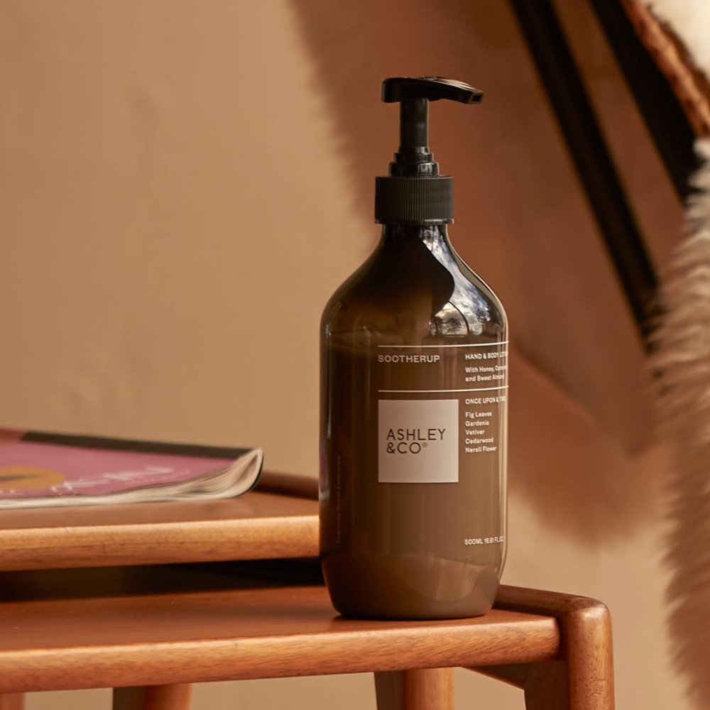 Brown bottle with pump labeled 'Ashley & Co' Sootherup on a wooden surface.