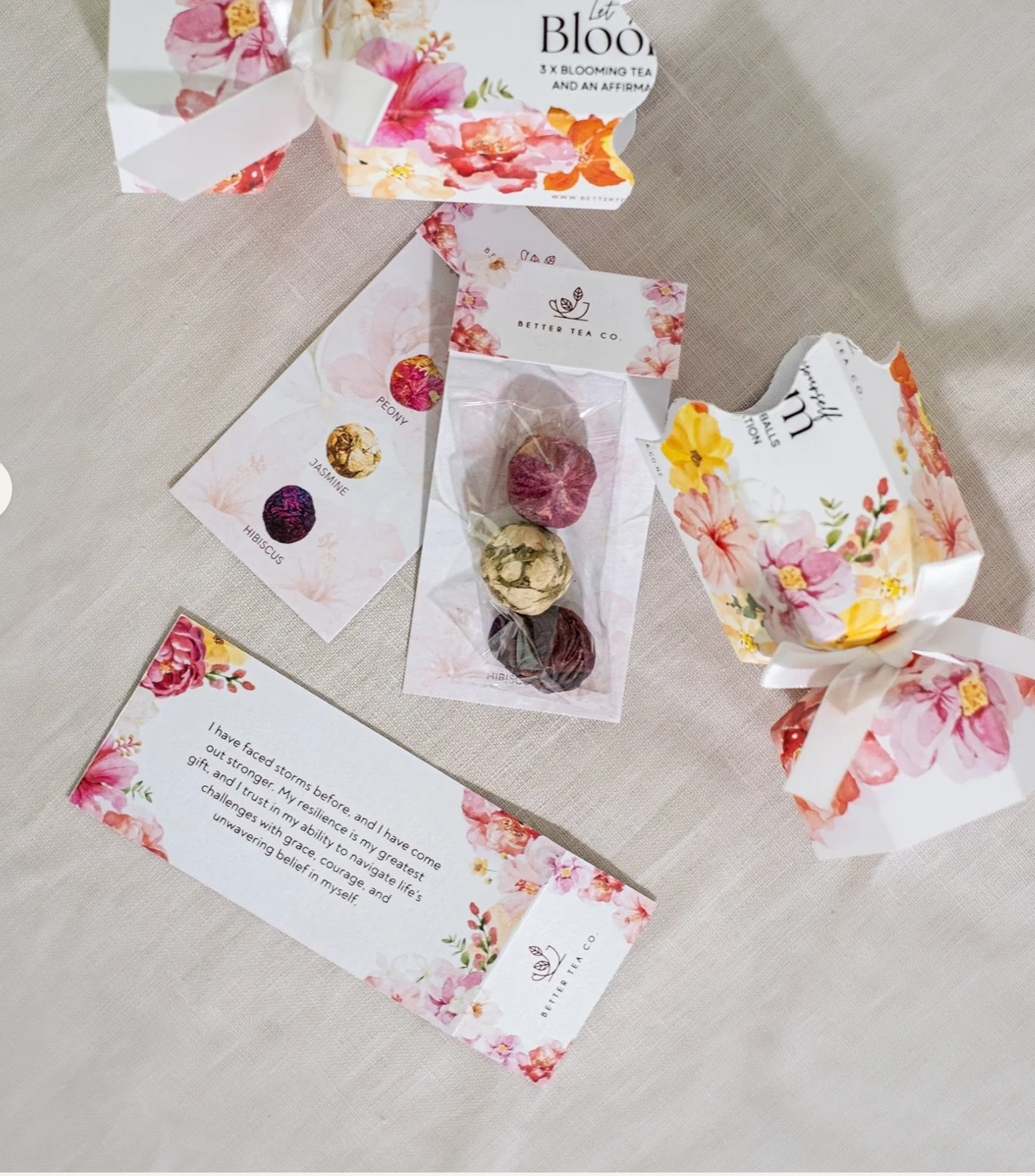 Floral packaging with blooming tea and cards on a light surface