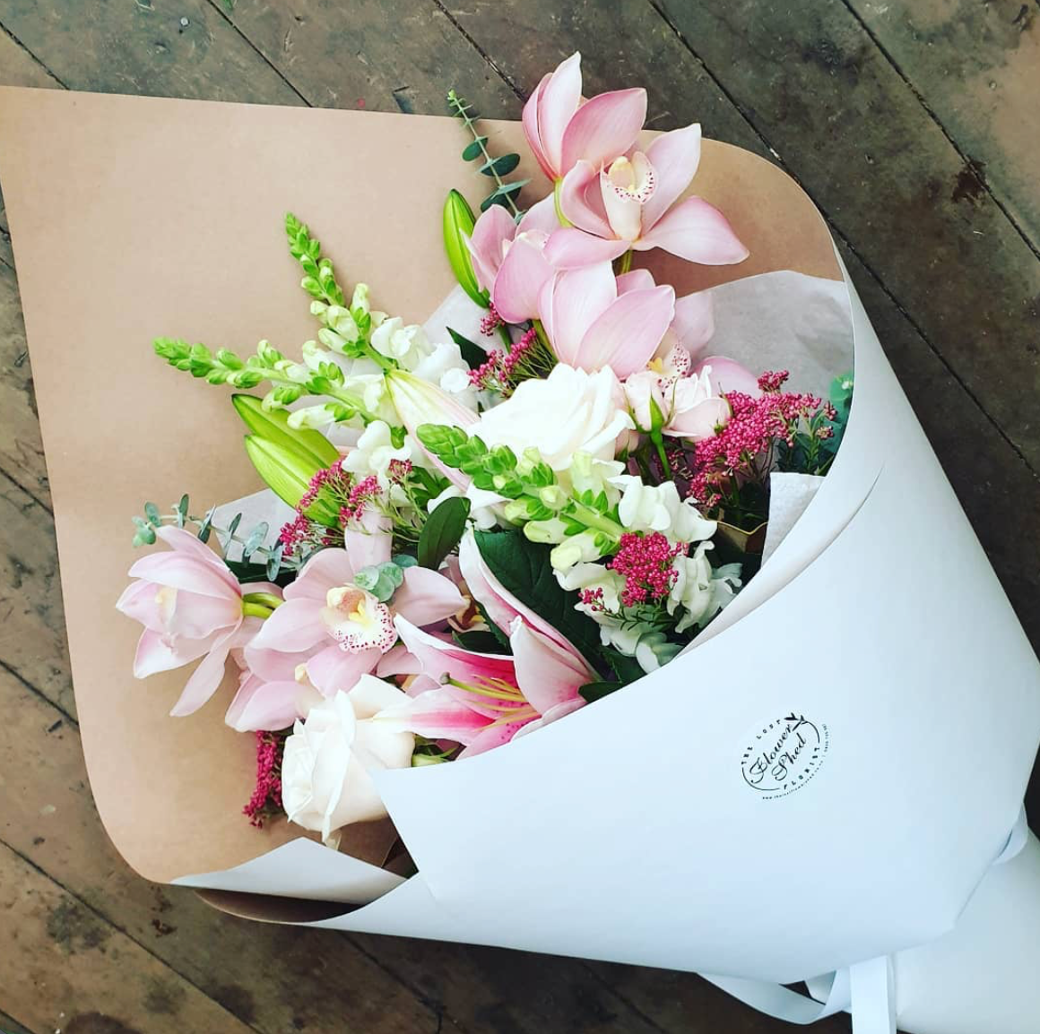 pink bouquet of white snap dragons, pink irises and lilies and white roses