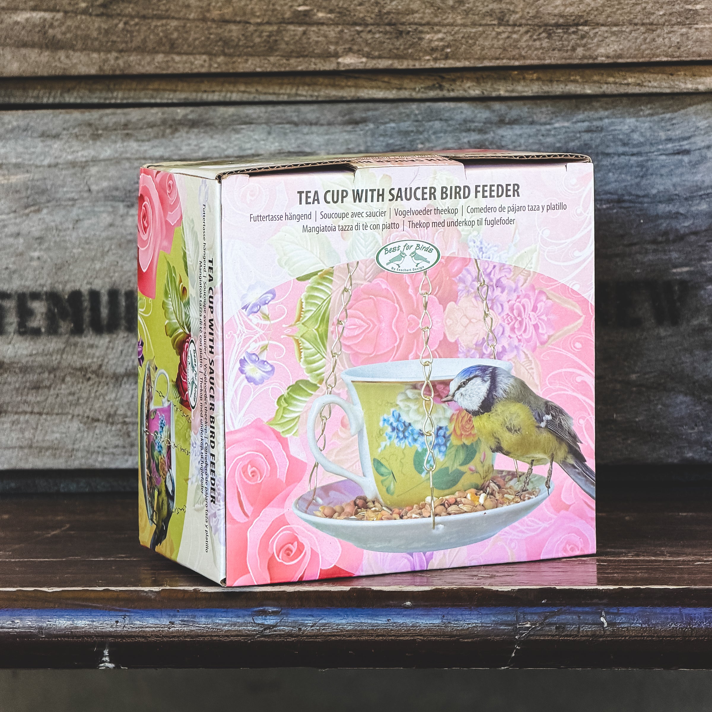 Box for a tea cup with saucer bird feeder on a wooden surface
