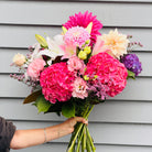 Fresh bouquet  held up infront of a wall from The Lost Flower Shed, Silverdale – same-day delivery North Shore, next-day Auckland