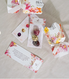 Floral packaging with blooming tea and cards on a light surface