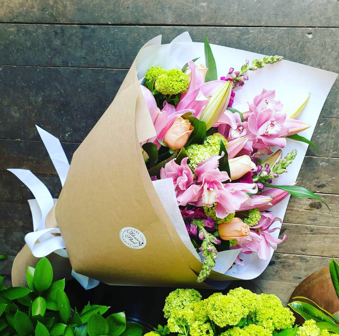 bouquet of pink orchids and pink lilies and apricot roses