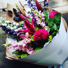 Florists choice bouquet of delphiniums, orchids, peonies and pink lilies