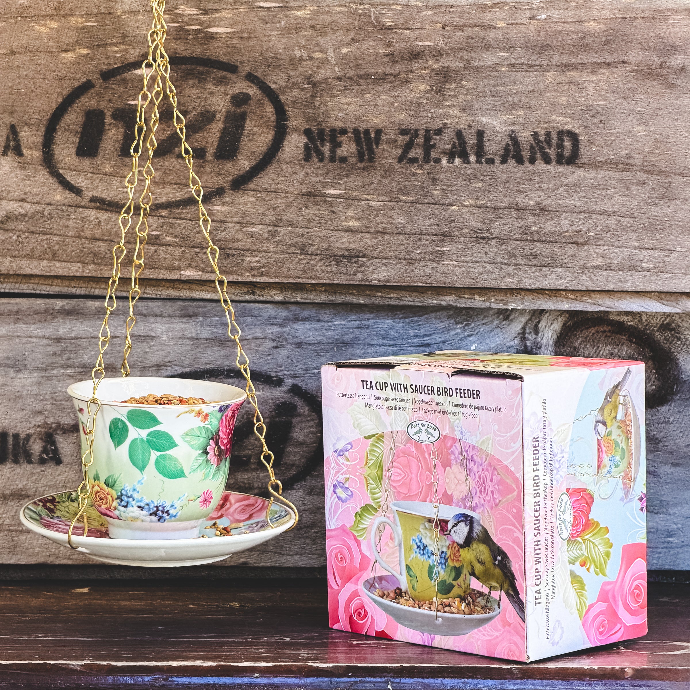 Tea cup with saucer bird feeder and packaging on a wooden background