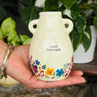 A tall cylindrical mini bud vase with floral design and text ' Life is better with you in it'.