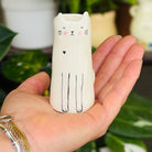 A tall cylindrical mini bud vase with floral design and text ' Life is better with you in it'.