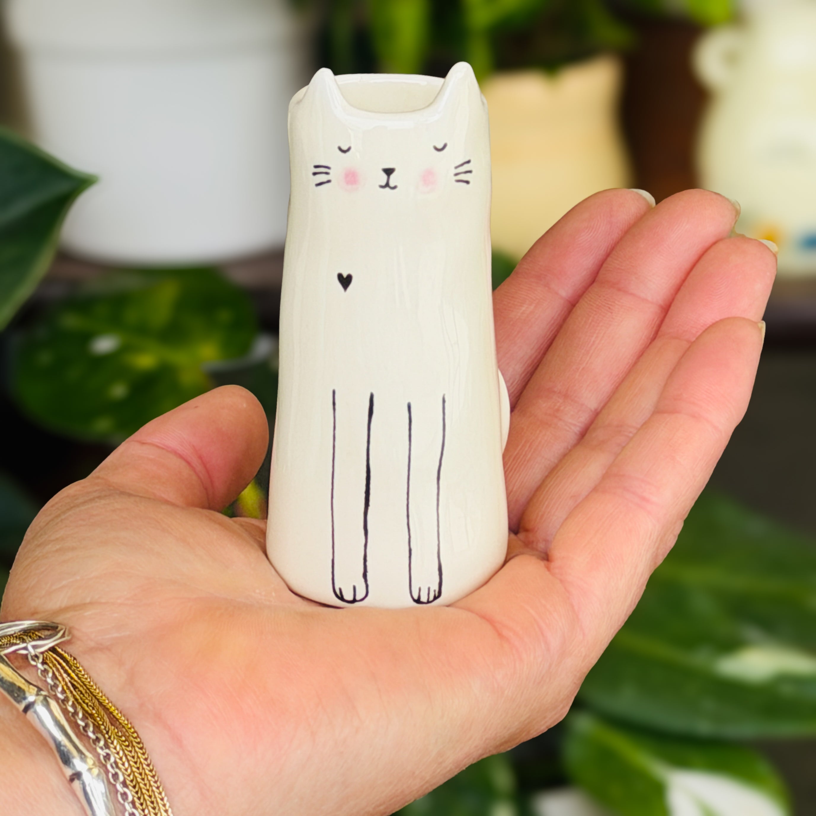 A tall cylindrical mini bud vase with floral design and text ' Life is better with you in it'.