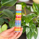 A tall cylindrical mini bud vase with floral design and text ' Life is better with you in it'.